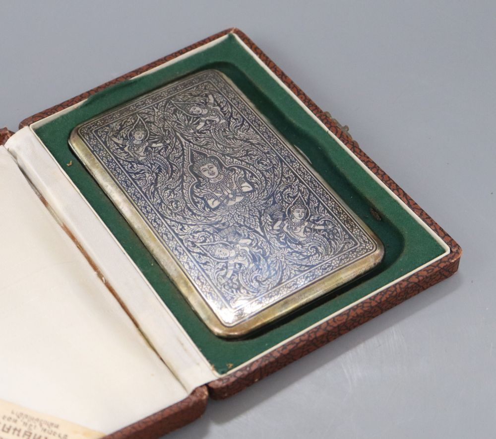 A cased mid 20th century Siamese sterling and niello cigarette case, 13.8cm, gross 5oz.